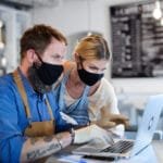 Coffee shop owners with face masks, lockdown, quarantine, coronavirus, back to normal concept.